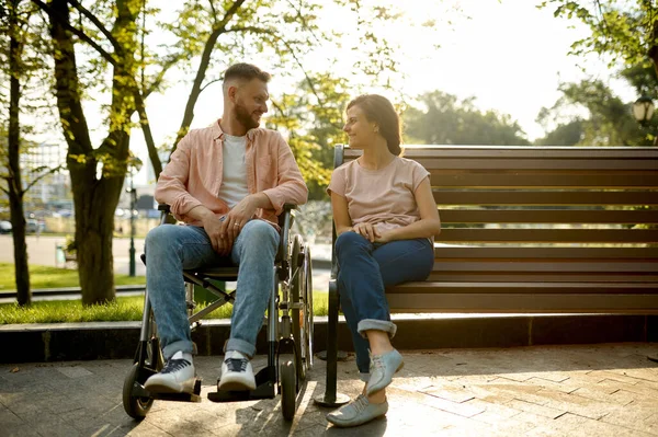 駐車場のベンチに座っている車椅子のカップル — ストック写真