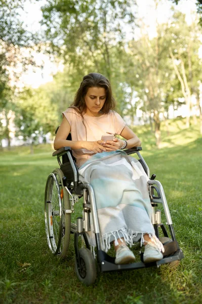 Behinderte Frau im Rollstuhl benutzt Handy — Stockfoto