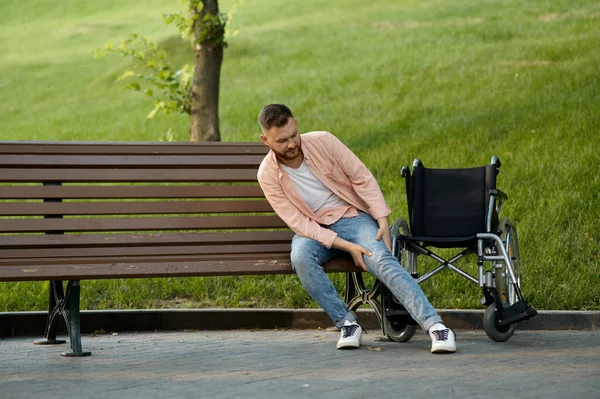 Behinderter wechselt vom Rollstuhl auf die Bank — Stockfoto