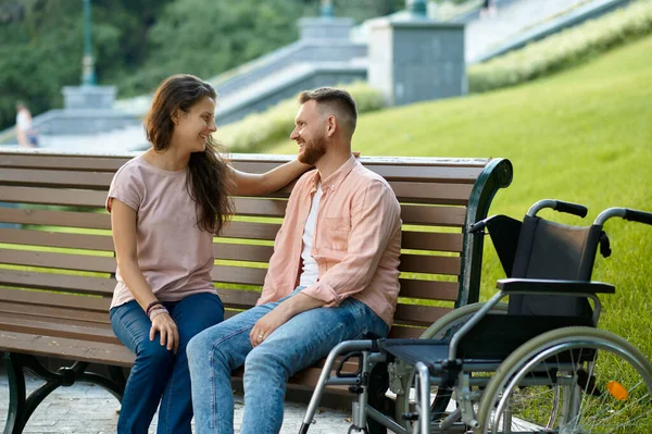 Kerekesszékes pár pihenés a padon a parkban — Stock Fotó