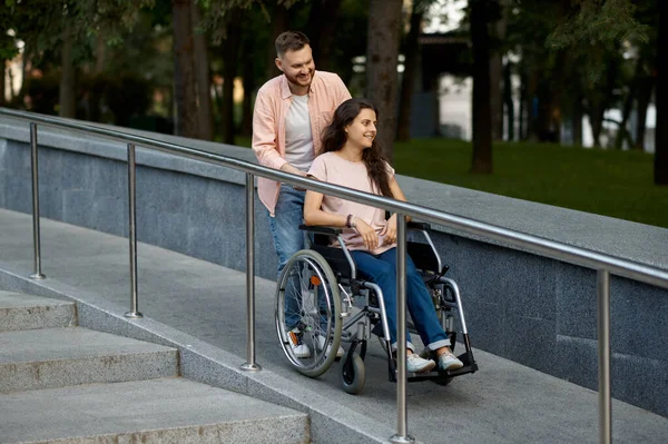 Liebespaar mit Rollstuhl geht im Herbstpark spazieren — Stockfoto