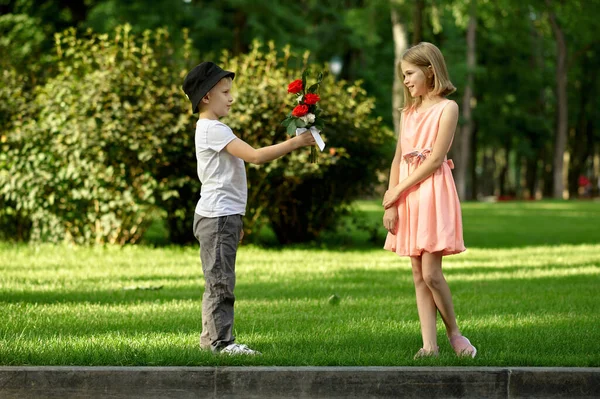 어린 시절 데이트 남자가 여자에게 꽃을 주고 — 스톡 사진