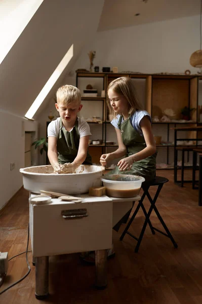 Children work on a potters wheel in the workshop — Stock Photo, Image