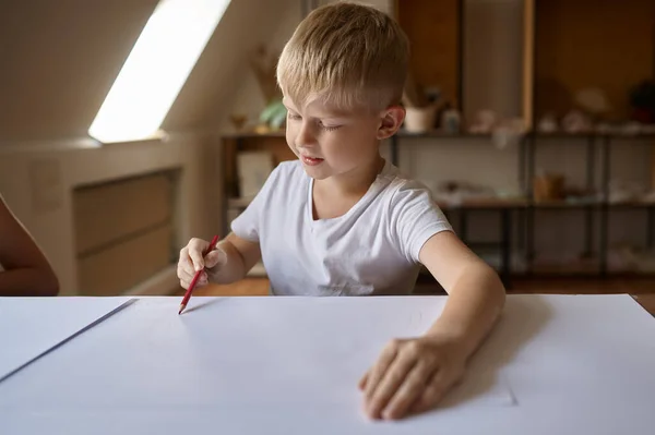 Kleiner Junge zeichnet am Tisch, Kind in der Kunstwerkstatt — Stockfoto