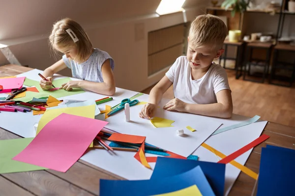 Twee kinderen werken met gekleurd papier in de werkplaats — Stockfoto