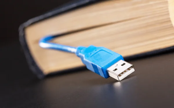 USB-kabeln sticker ut från boken — Stockfoto