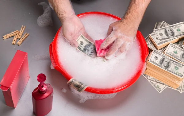 As mãos estão lavando dólares em espuma — Fotografia de Stock