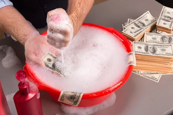 Las manos están lavando billetes de dólares en espuma — Foto de Stock