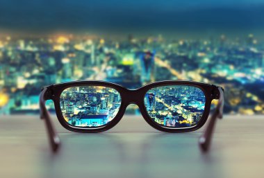 Night cityscape focused in glasses lenses clipart