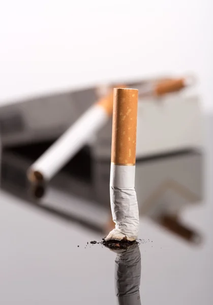 Cigarette butt against box — Stock Photo, Image