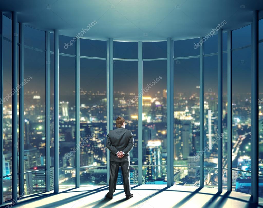 Man sitting beside glass window near high rise building photo