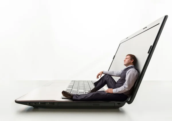 Jeune homme assis sur un ordinateur portable — Photo