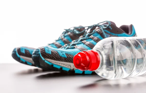 Zapatos deportivos y botella de agua — Foto de Stock