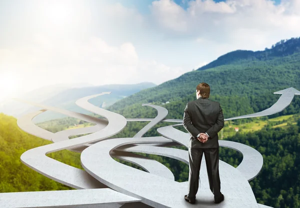 Businessman stands choosing his way — Stock Photo, Image