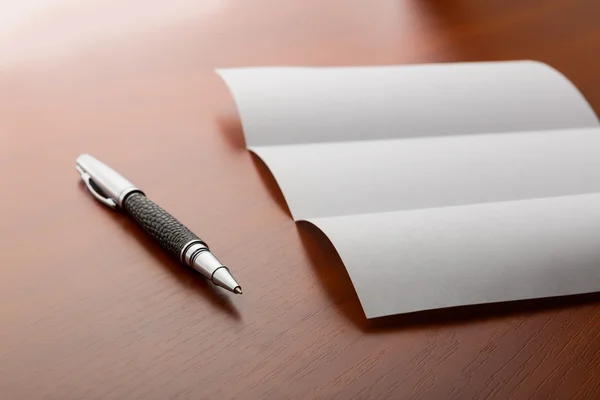 Folha de papel e caneta na área de trabalho — Fotografia de Stock