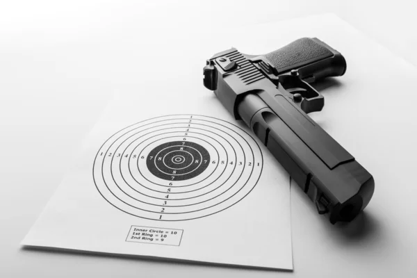 Paper target and pistol on white — Stock Photo, Image