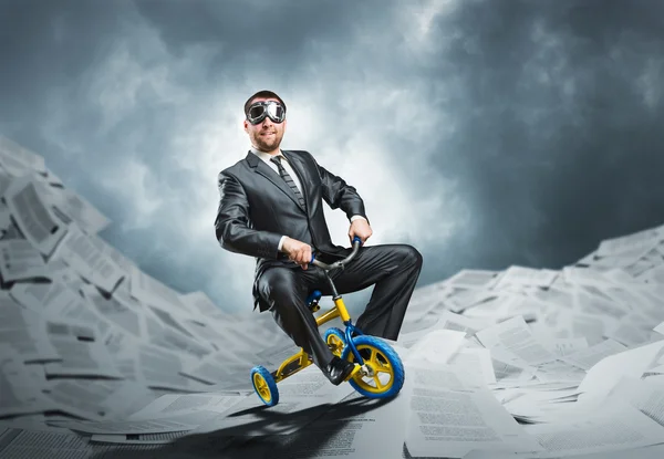 Homem de negócios estranho montando uma bicicleta pequena — Fotografia de Stock