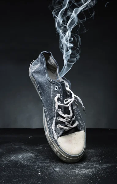 Old gym-shoe  in smoke — Stock Photo, Image