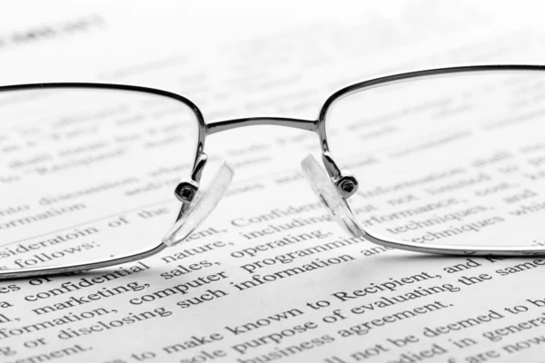 Glasses on newspaper. Macro — Stock Photo, Image