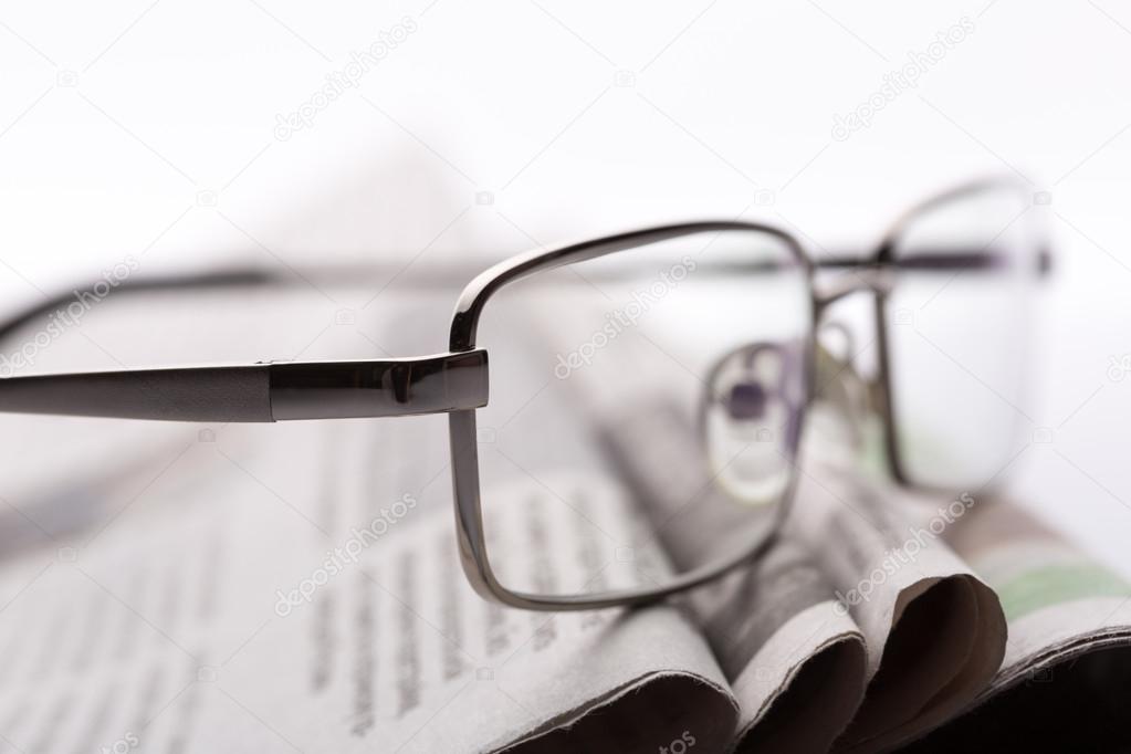 Glasses on the newspapers closeup
