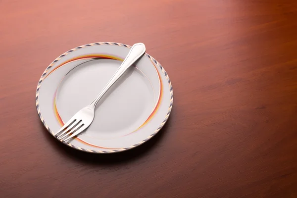 Белая тарелка и вилка — стоковое фото