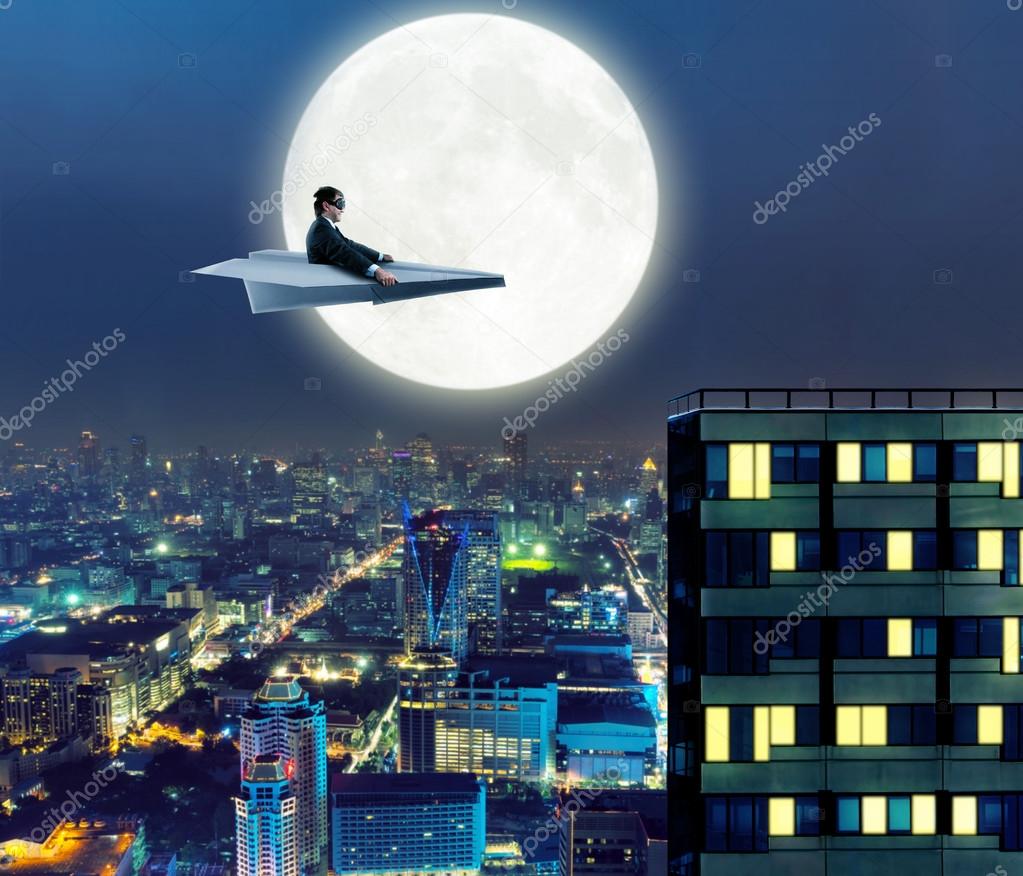 Man on paper airplane above  city