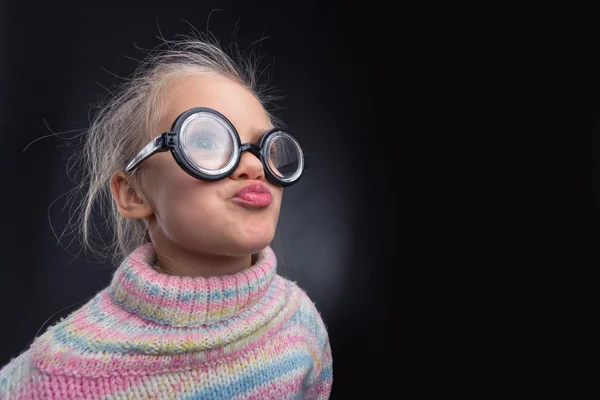 Meisje in glazen maakt gezichten — Stockfoto