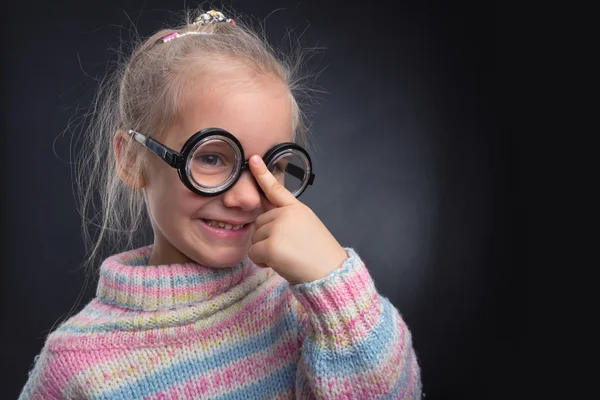 Menina em óculos faz rostos — Fotografia de Stock