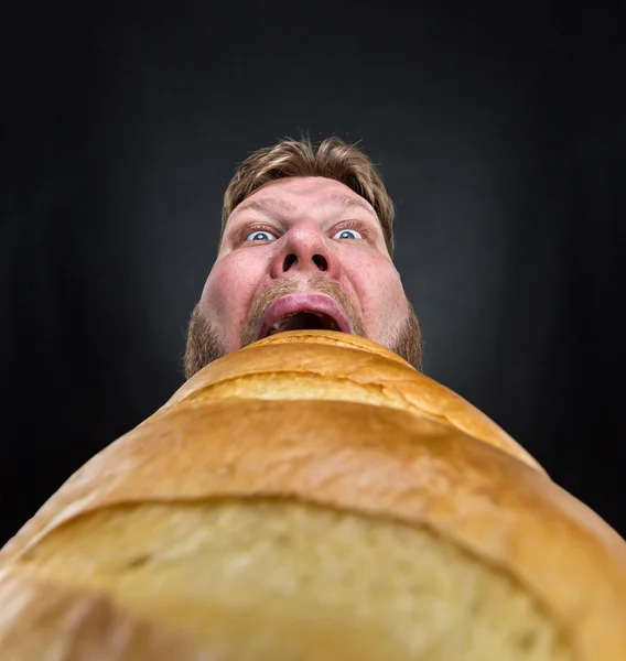 Man die een grote brood eten — Stockfoto