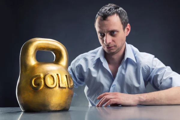 Businessman with gold kettlebell — Stock Photo, Image