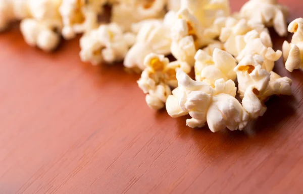 Popcorn na drewnianym stole — Zdjęcie stockowe