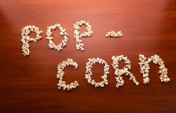 Słowo pop-corn na stole — Zdjęcie stockowe