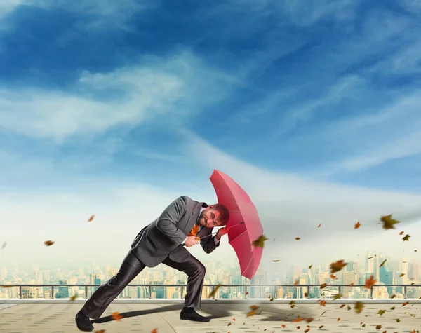 Business man protects himself with umbrella — Stock Photo, Image