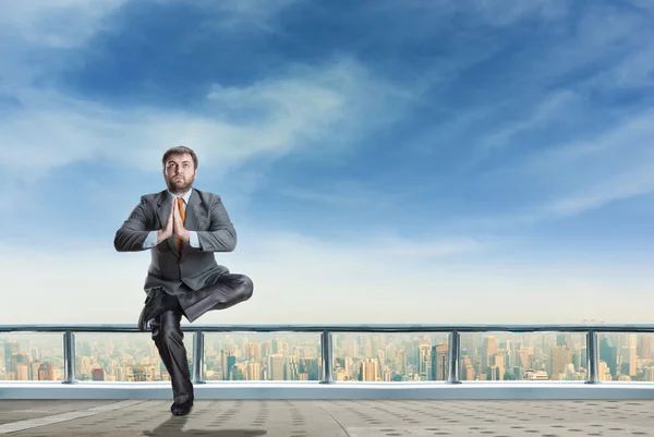 Geschäftsmann meditiert über Wolkenkratzer — Stockfoto