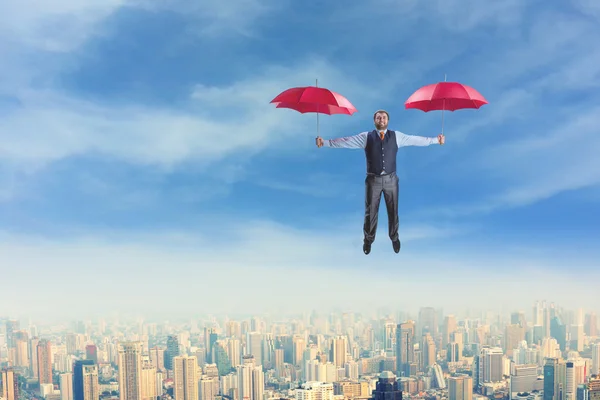 Бизнесмен, летающий с зонтиками — стоковое фото