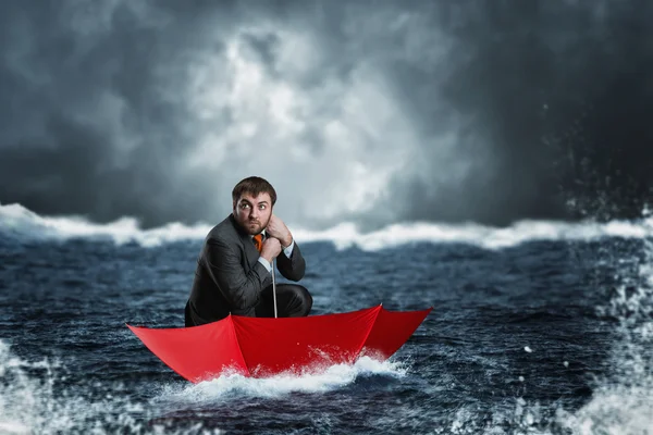 Empresario en paraguas navega en el mar — Foto de Stock