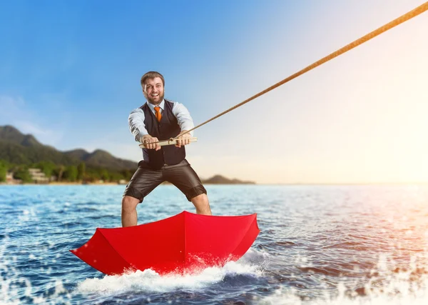 Happy businessman surfing on water — Stock Photo, Image