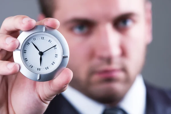 Serious businessman with clock — Stock Photo, Image