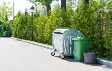 Metal ve yeşil plastik çöp tenekeleri