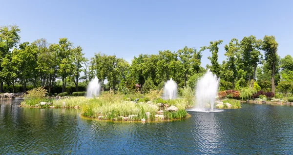 Pond in spring park with fountains — Stock Photo, Image