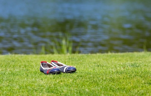 Sapatos de mulher em pé na grama — Fotografia de Stock