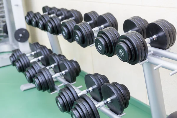Dumb-bells on the stand in gym — Stock Photo, Image