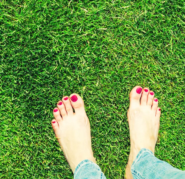 Pies desnudos de pie sobre la hierba — Foto de Stock