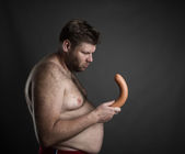 fat man looking at sausage