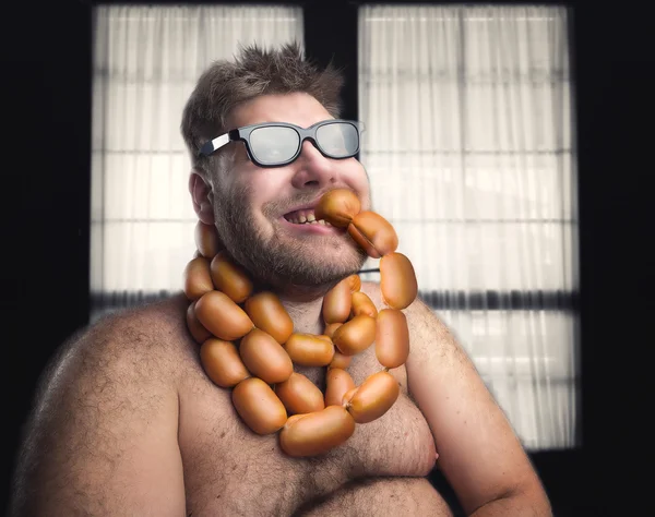 Homem gordo comendo salsichas — Fotografia de Stock