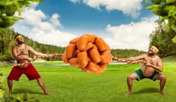 Uomini che lottano per mucchio di salsicce — Foto Stock