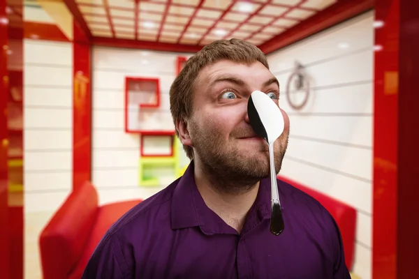Hombre sosteniendo cuchara en la nariz — Foto de Stock