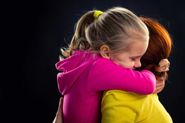 Kleines Mädchen umarmt ihre Mutter — Stockfoto