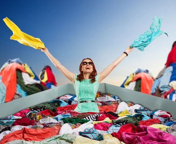 Mujer joven con un montón de ropa — Foto de Stock