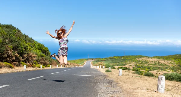 Mujer joven saltando en el camino — Foto de Stock